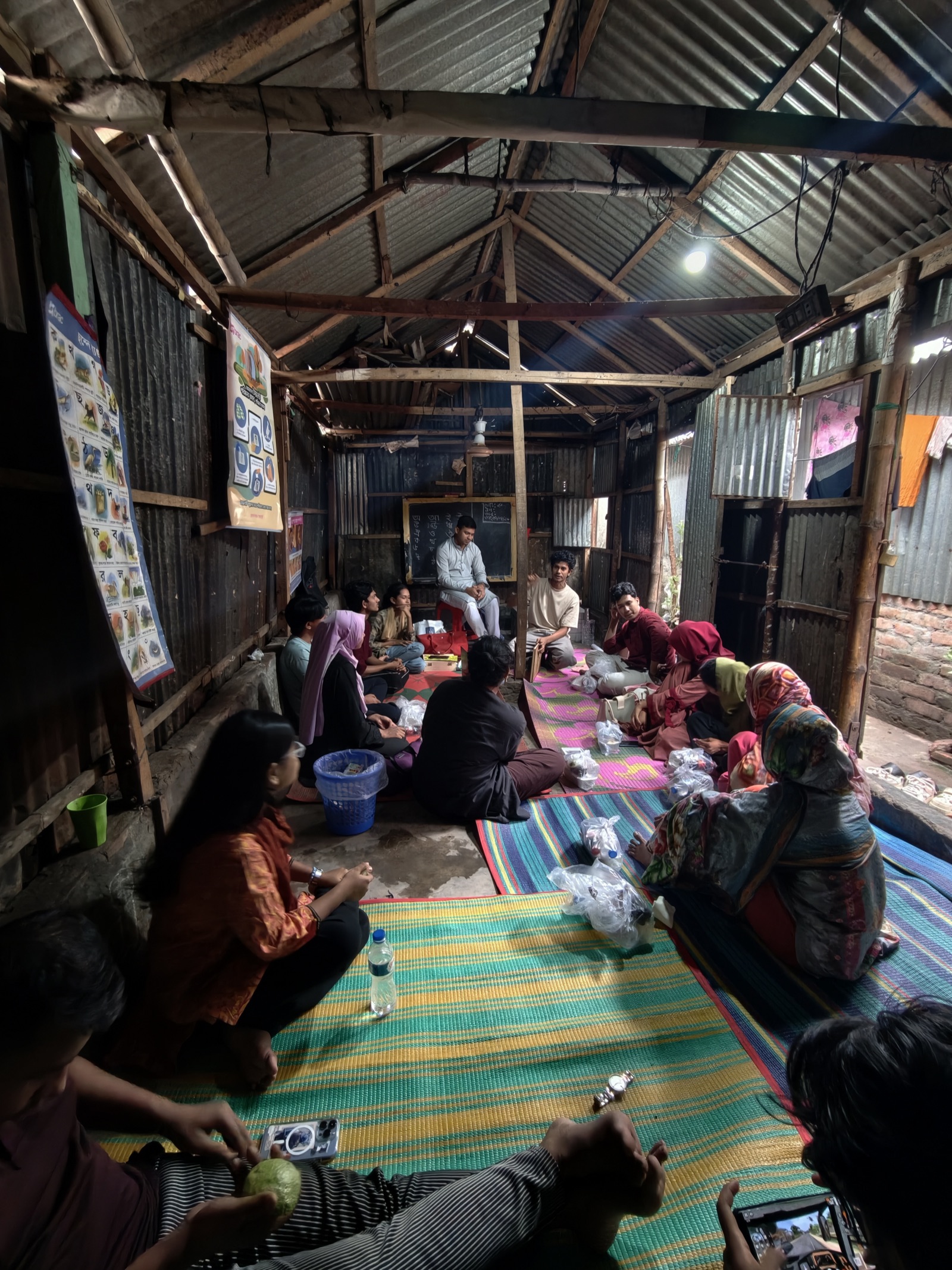 Participants and facilitators seated in a circle inside a Korail community room during a workshop session