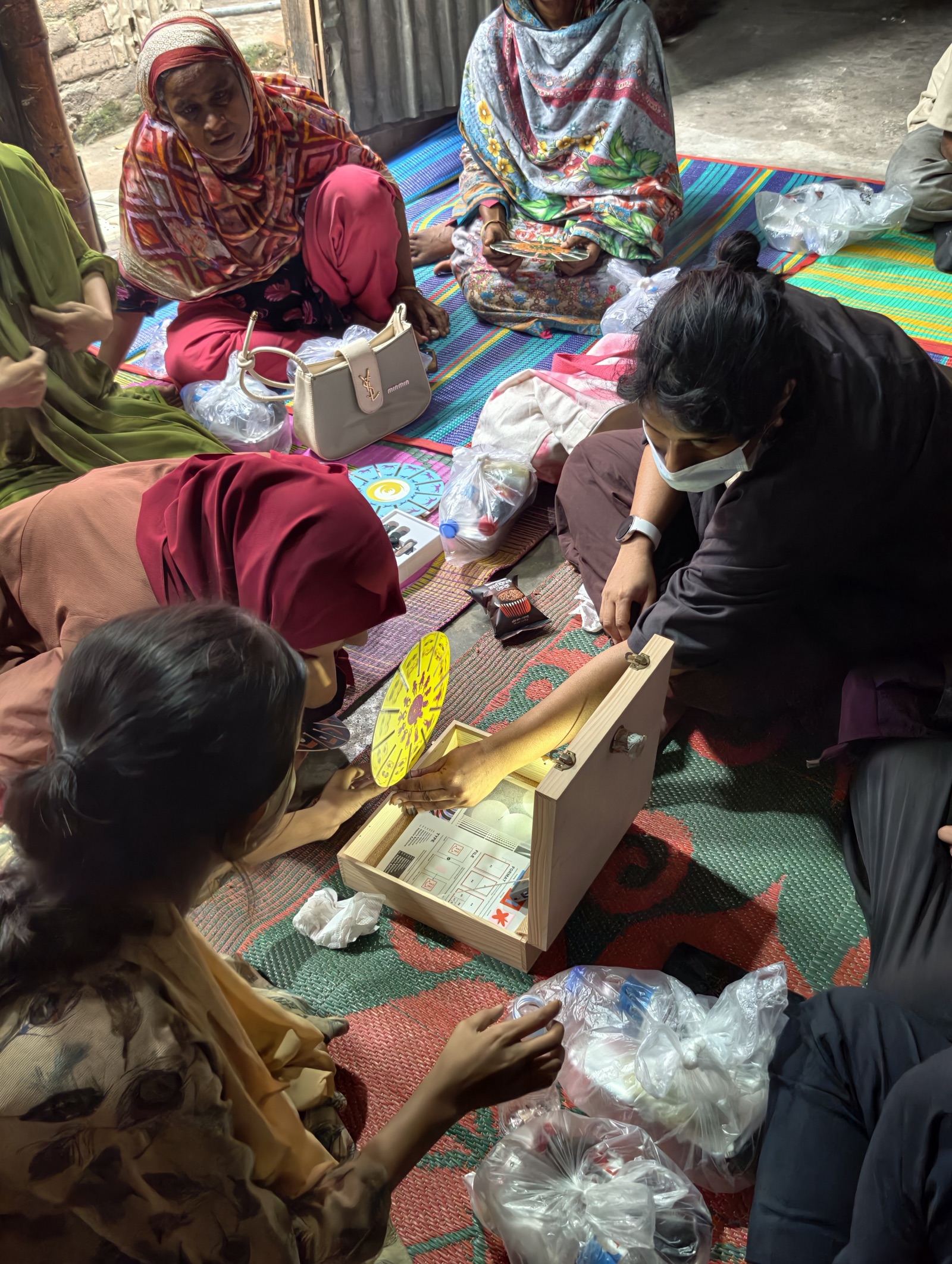 Participants and a facilitator gathered around a hand-built spinning-disc mechanism during a Korail workshop session